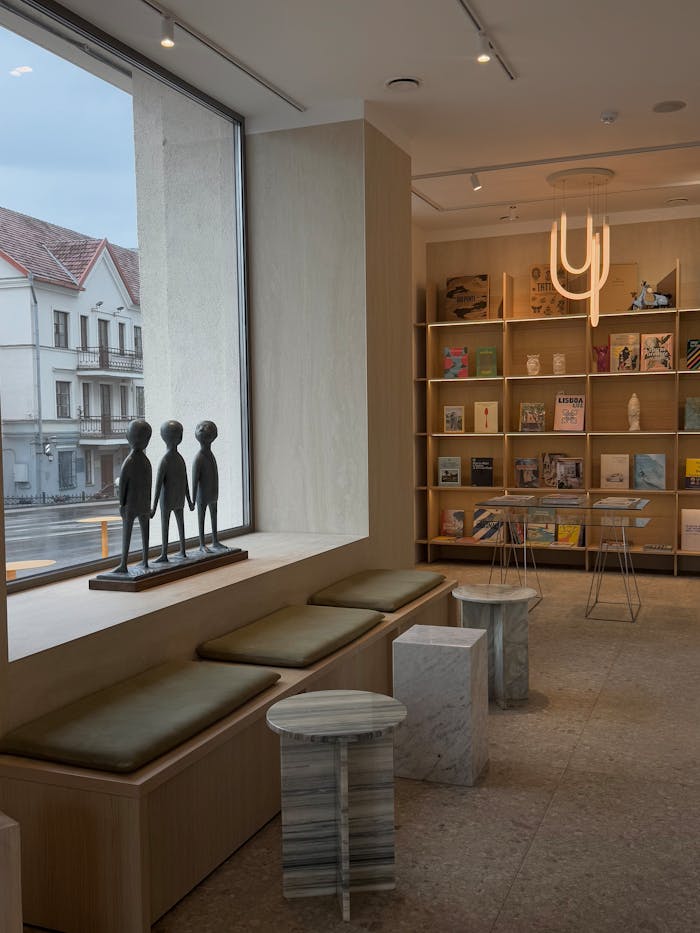 Elegant bookstore interior with sculpture and seating by a large window.